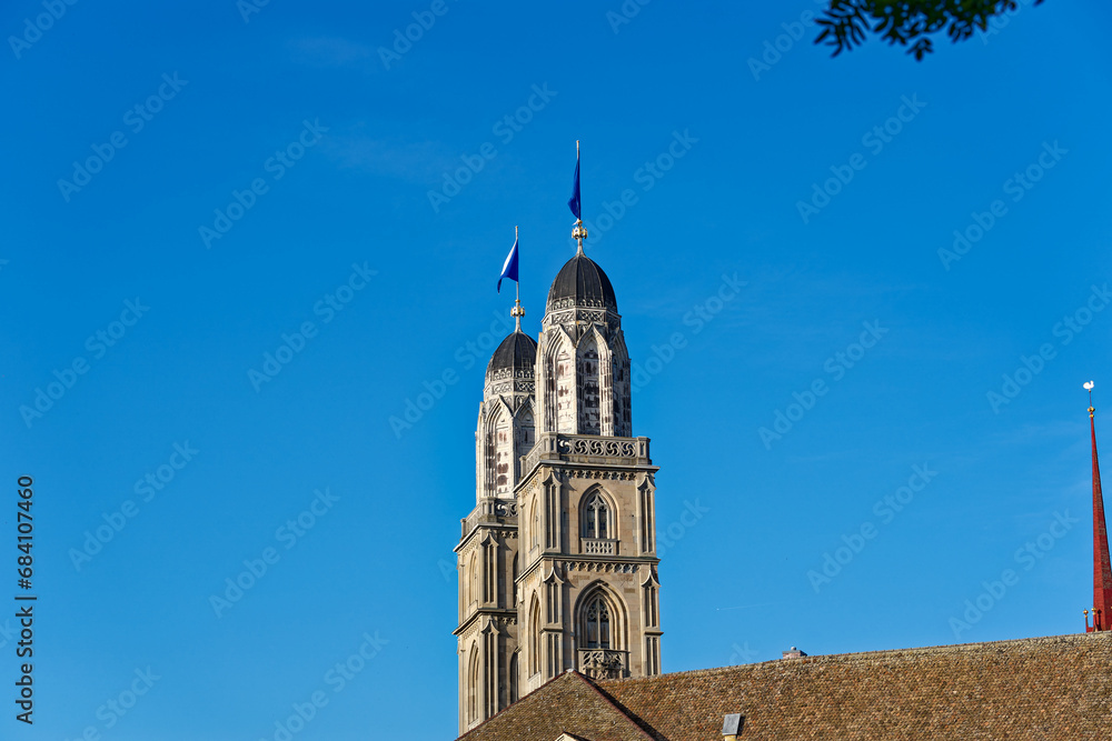 Twin towers with flags of City of Zürich and Canton Zürich on top of church towers of protestant church Great Minster on a sunny summer evening. Photo taken July 7th, 2023, Zurich, Switzerland.
