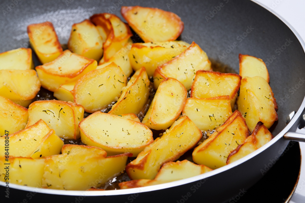 potato dish. Golden fried potatoes lie in a frying pan, rosy fried potatoes on the stove potato dish. Golden fried potatoes lie in a frying pan, rosy fried potatoes on the stove