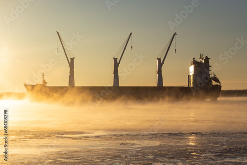  Cargo ship, ice classed bulk carrier in the ice and fog of a freezing river. High quality photo
