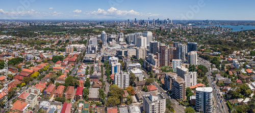 Panoramic aerial drone view of Bondi Junction in the Eastern Suburbs of Sydney, NSW Australia with Sydney City in the background on a sunny day photo