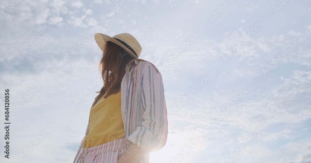 Happy young female in beach hat, low angle, portrait. Camera rotation gimbal
