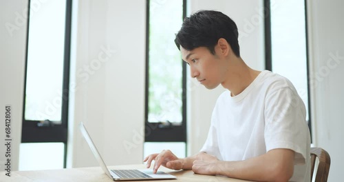 ノートパソコンを見て喜ぶ男性