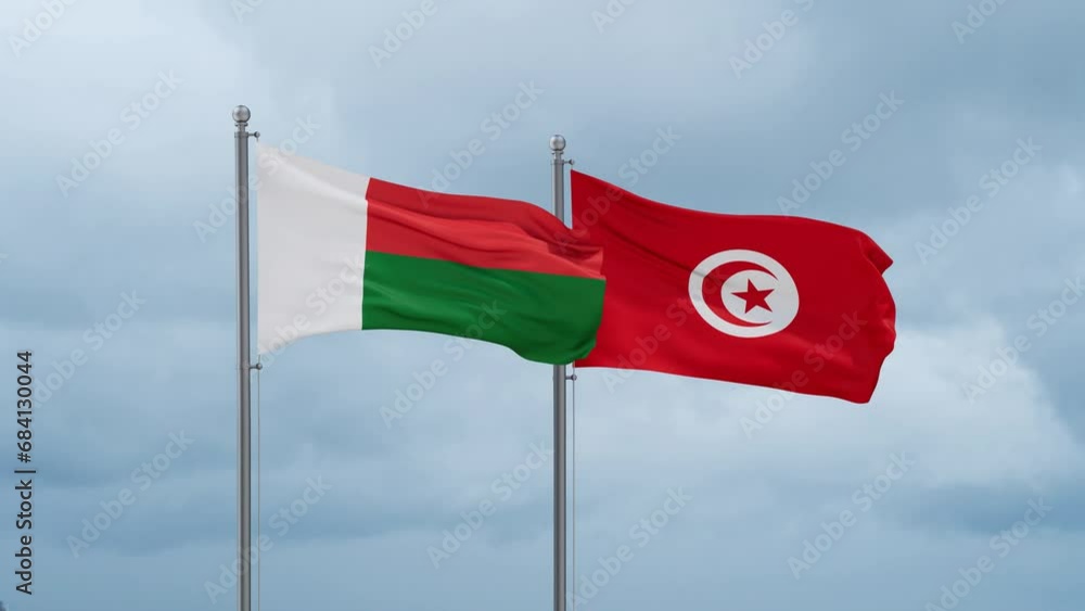 Tunisia and Madagascar flag waving together on cloudy sky, endless seamless loop, two country cooperation concept Tunisia and Madagascar flag waving together on cloudy sky, endless seamless loop, two country cooperation concept