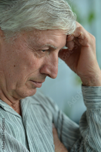 Portrait of an thinking elderly man on a gray background photo