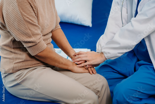 Asian female hands touching senior male hand Helping hands take care of the elderly concept in hospital.