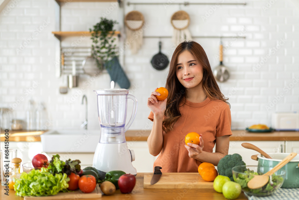Portrait of beauty healthy asian woman making orange fruit smoothie with blender.girl preparing cooking detox cleanse with fresh orange juice in kitchen at home.health, vitamin c, diet, healthy drink Portrait of beauty healthy asian woman making orange fruit smoothie with blender.girl preparing cooking detox cleanse with fresh orange juice in kitchen at home.health, vitamin c, diet, healthy drink