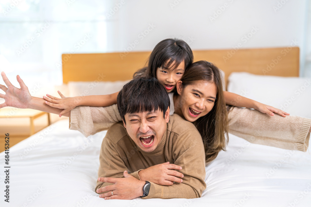 Portrait of enjoy happy love asian family father and mother holding hug cute little asian girl child smiling play and having fun moments good time, care, kid, support, insurance, child, at home Portrait of enjoy happy love asian family father and mother holding hug cute little asian girl child smiling play and having fun moments good time, care, kid, support, insurance, child, at home
