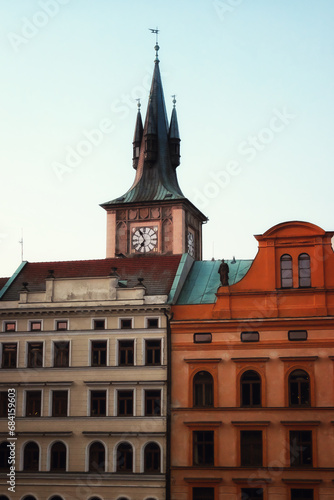 A clock tower in Prague with a red roof and a blue sky.