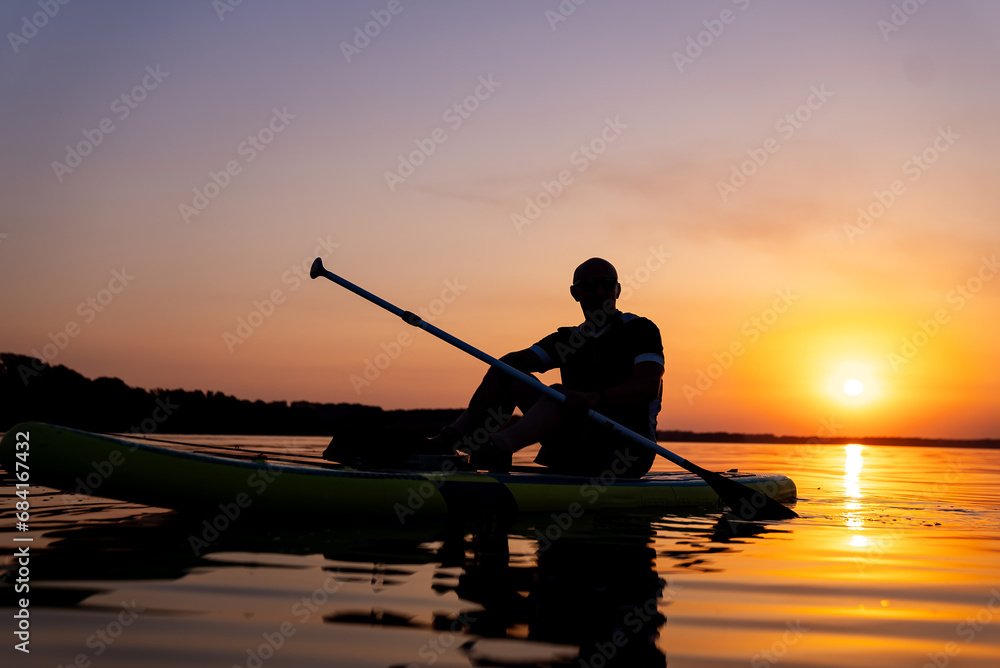 A Serene Moment: A Man Contemplating Nature's Beauty in a Kayak at Sunset