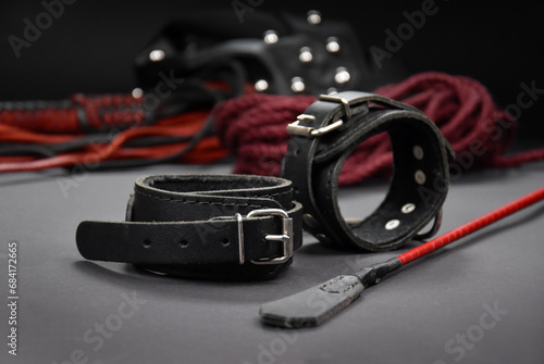 Leather handcuffs and a whip stock photo images. Sex toys for BDSM images. Set of erotic toys for adults only on a dark background