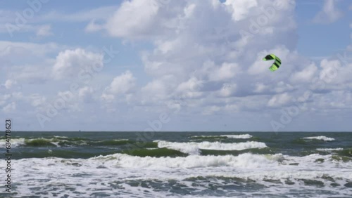An unrecognizable man is kitesurfing on a bright sunny day. Active recreation at sea.