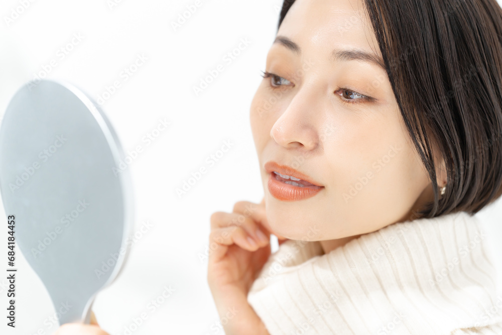 手鏡で肌を確認する女性