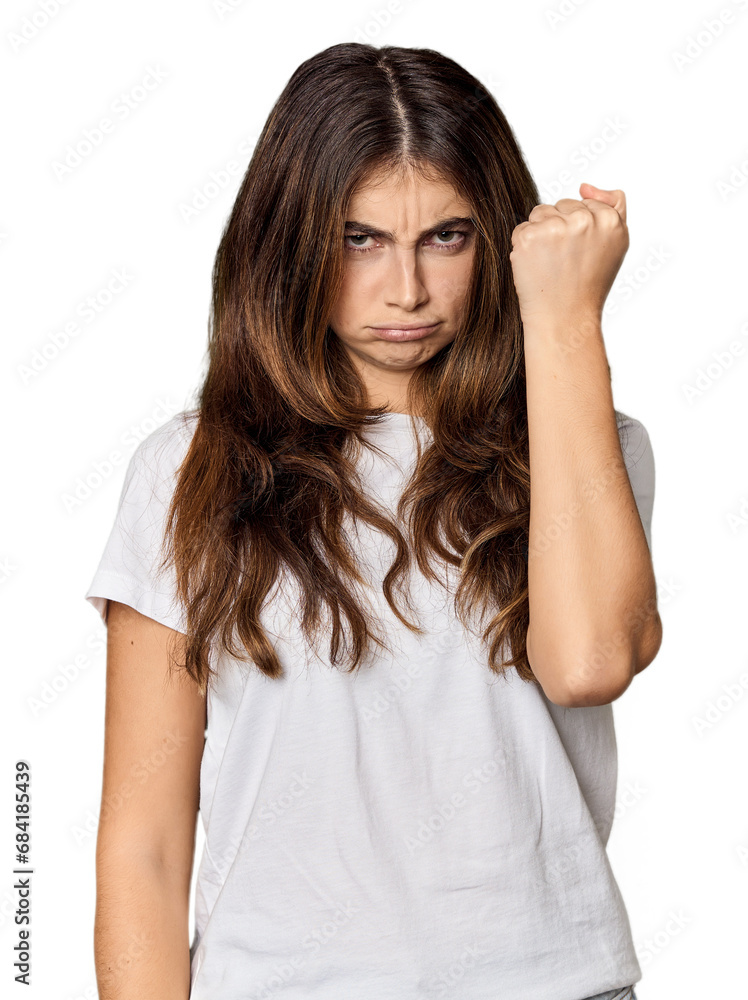 Young Caucasian woman in studio setting showing fist to camera, aggressive facial expression. Young Caucasian woman in studio setting showing fist to camera, aggressive facial expression.