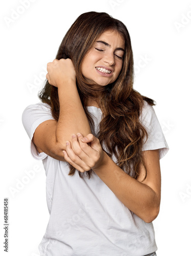 Young Caucasian woman in studio setting massaging elbow, suffering after a bad movement. © Asier