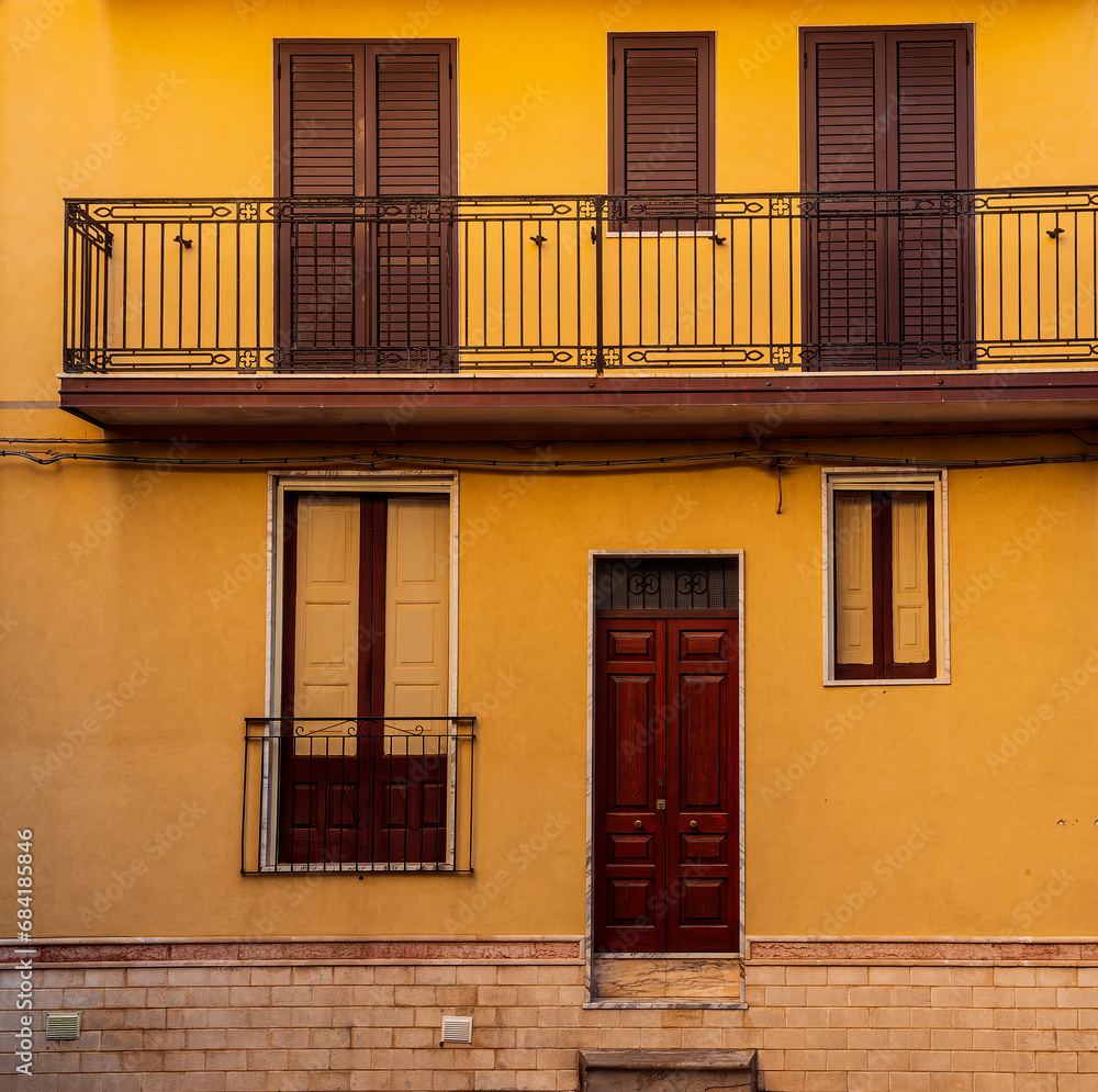 Obraz premium view of medeterranean street with vintage buildings , beautiful windows and picturesque balcony with attributes of traditional italian country life