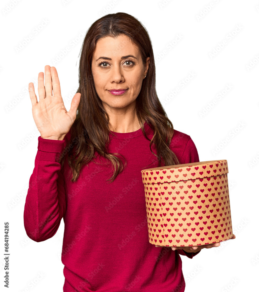 Middle-aged woman with Valentine's Day heart box in studio standing with outstretched hand showing stop sign, preventing you. Middle-aged woman with Valentine's Day heart box in studio standing with outstretched hand showing stop sign, preventing you.