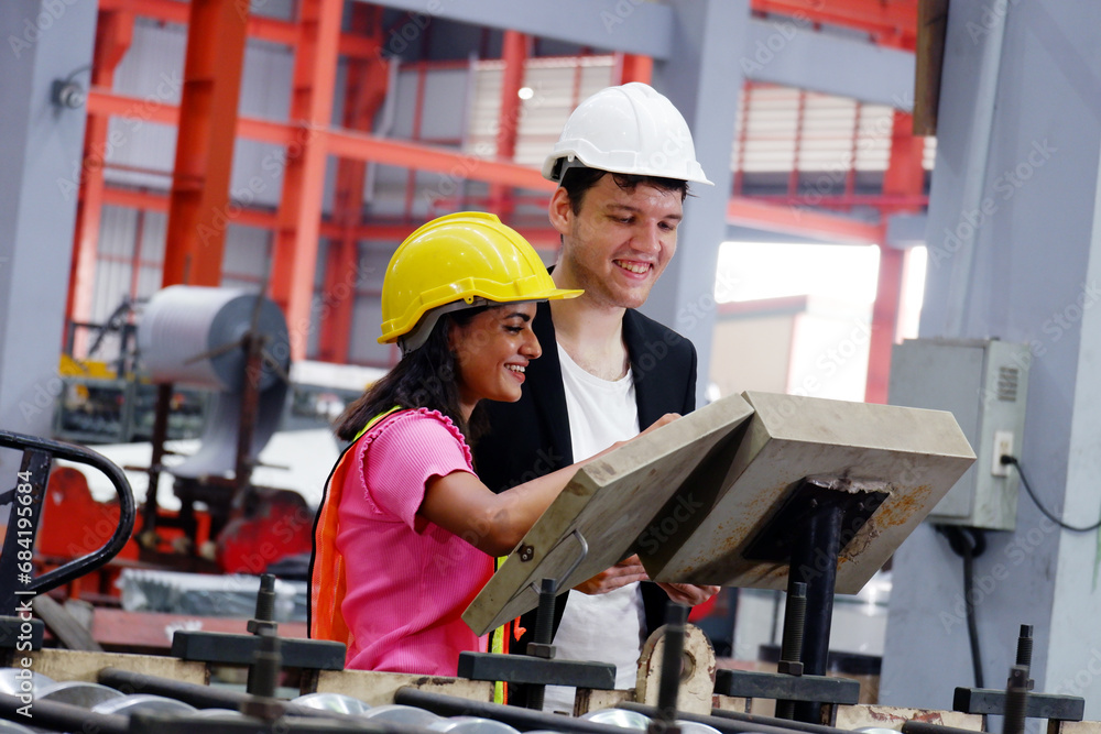 An electrical engineer is inspecting the electrical system at an electrical control cabinet in a factory. An electrical engineer is inspecting the electrical system at an electrical control cabinet in a factory.