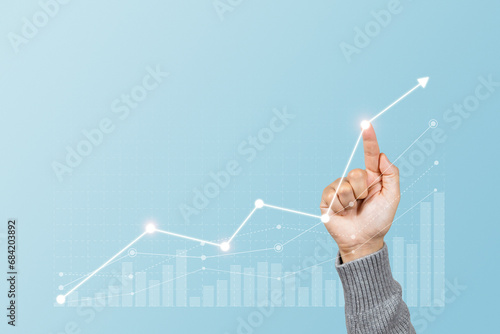 Man is touching arrows pointing up with graph as a symbol of growth and success or rising successful development and business development in the future photo