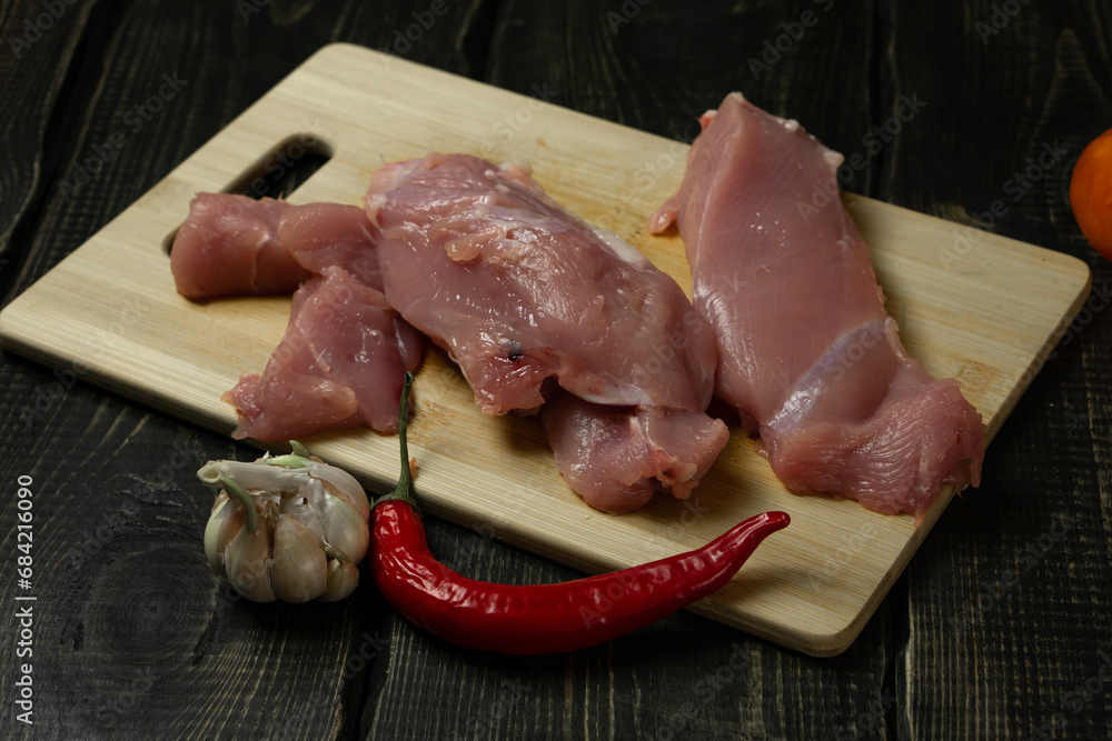 Raw chicken or turkey meat on a cutting board