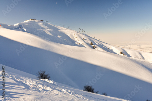 ski traces and fresh powder on the slopes of Amirsoy mountain resort (Tashkent region, Uzbekistan) photo