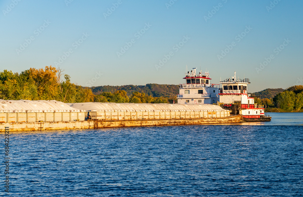 Large grain shipment on Upper Mississippi in barge being pushed by two large pusher tugs on river Large grain shipment on Upper Mississippi in barge being pushed by two large pusher tugs on river