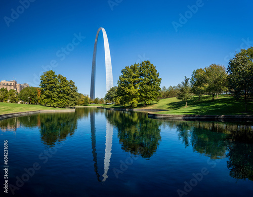 View across blue lake in the National Gateway Park to Gateway Arch in St Louis Missouri with reflection in the calm water photo