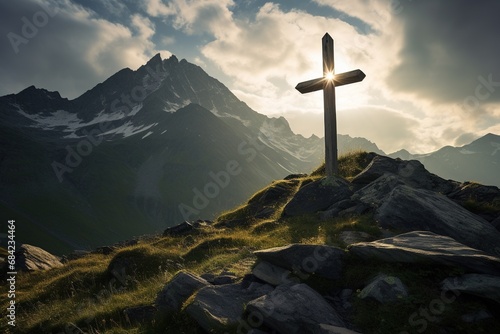 Wooden cross on the top of the mountain with clouds on the background