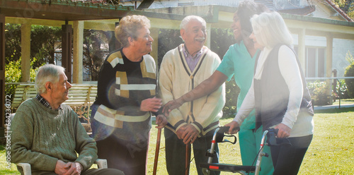 African nurse talking to two elderly retired couples outdoor in the rehab hospital garden. Happiness  rehabilitation and retirement concept