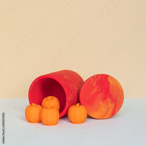 A candle holder with a lid and melting wax for candles in the shape of a pumpkin.