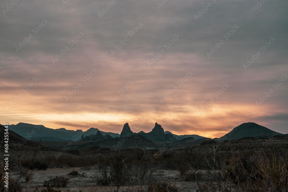 Sun Rises Into Thick Clouds Over Mule Ears In Big Bend