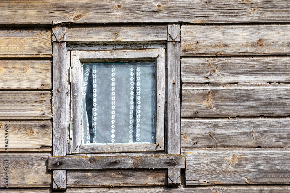 an old wooden house with a wooden window pane in the wall and curtains behind it
an old wooden house with a wooden window pane in the wall and curtains behind it