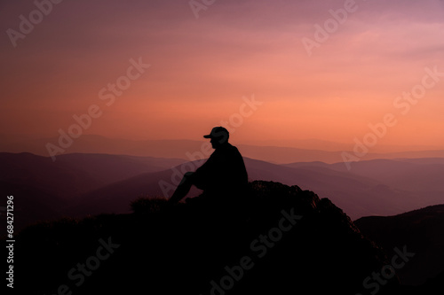 A man who hikers enjoys a break look at the top of the mountain adventure travel.