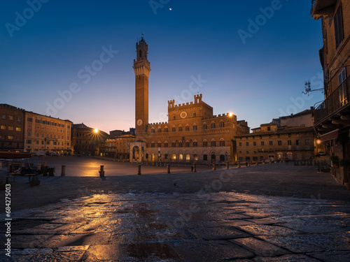 Illuminated Palazzo Pubblico with Torre del Mangia tower on Piazza del Campo at night, Siena, Italy