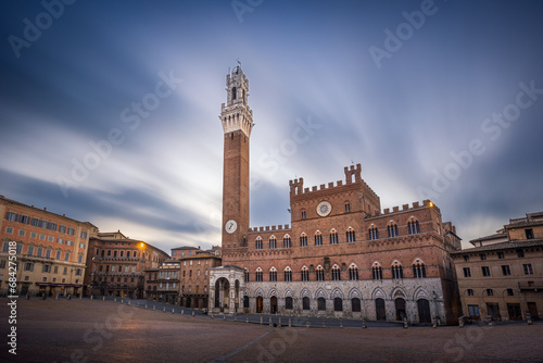 Medieval Palazzo Pubblico with Torre del Mangia tower on empty Piazza del Campo square, Siena, Italy photo