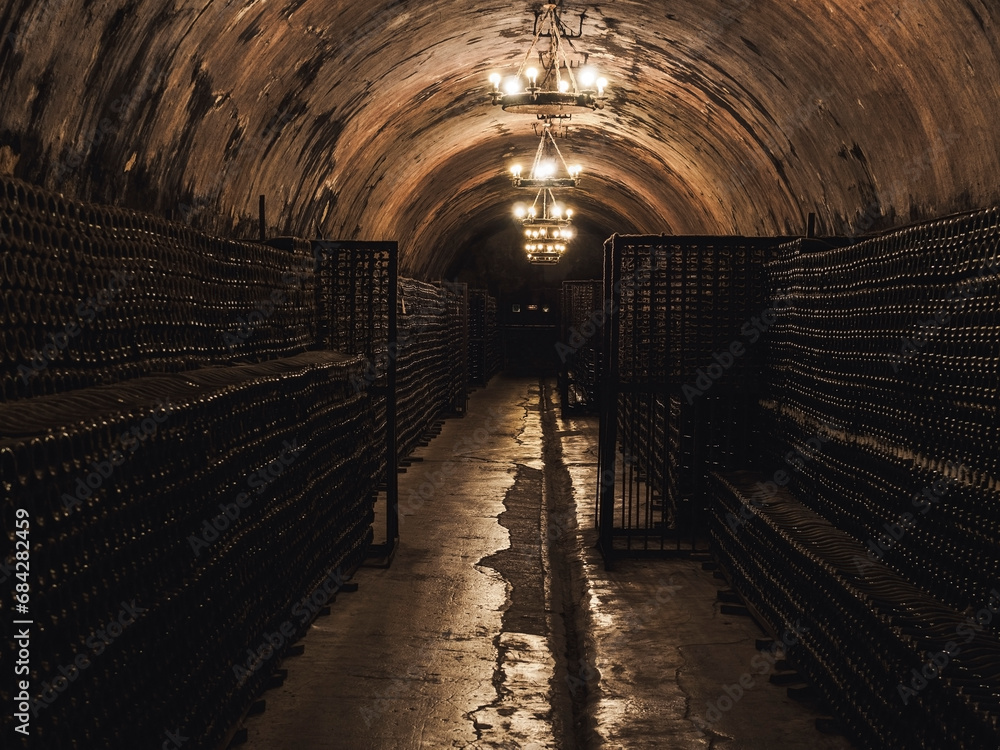 rows with bottles of sparkling wine in the corridor of old winery.