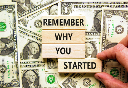 Remember why you started symbol. Concept word Remember why you started on wooden block. Dollar bills. Beautiful background from dollar bills. Business remember why you started concept. Copy space.