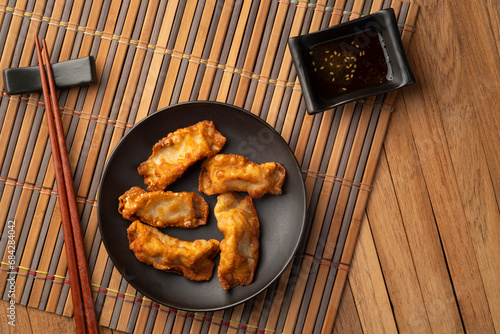 gyoza,Deep fried crispy dumplings with pork and vegetables on black plate.Top view photo