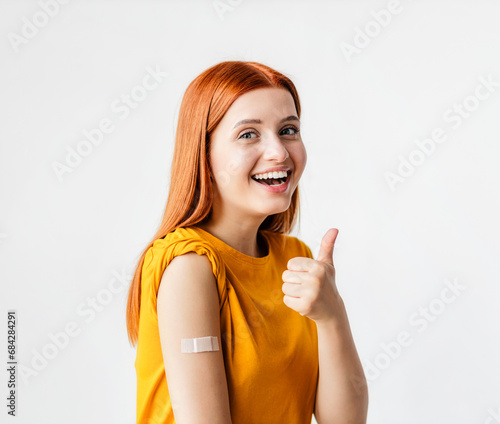 Fotografie Portrait of a red-haired smiling young woman after getting a vaccine standing on