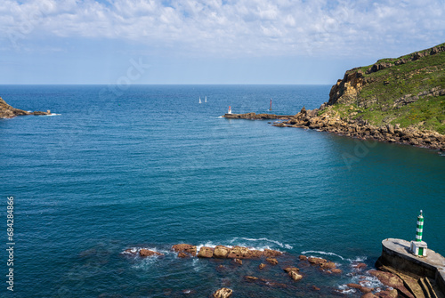 View over the beautiful entrance of the Ria de Pasaia, a small fjord at the Cantabrian Sea. Lighthouses, sailing boats and green hills, ideal for hiking.