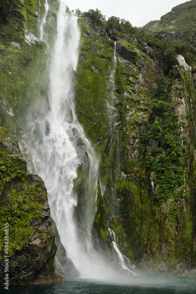 Naklejka premium waterfall in the fjords of milford sound, new zealand