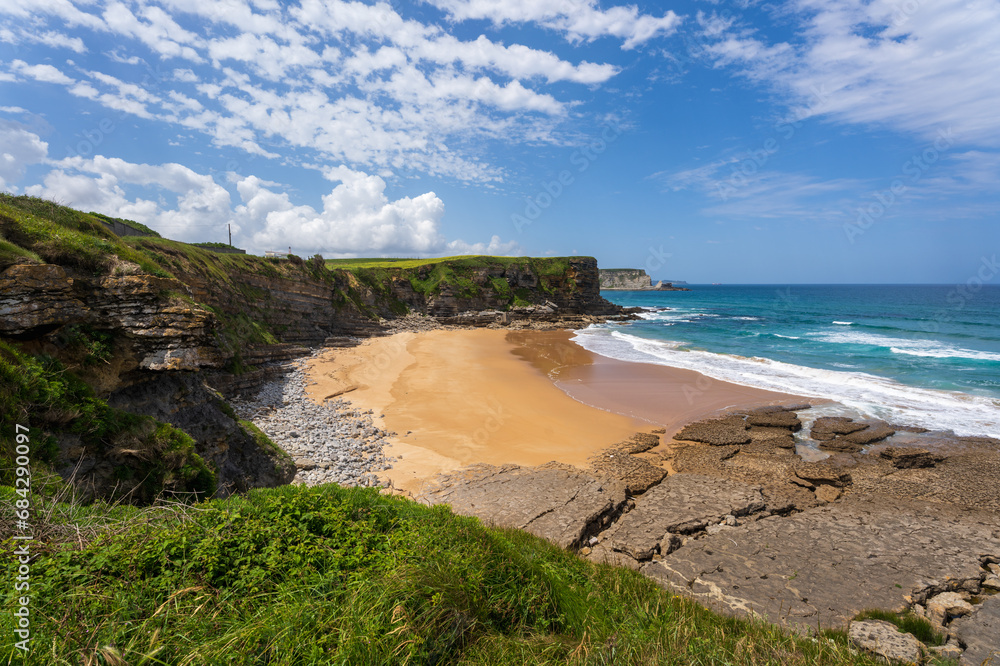 Playa de Arenillas beach is a sandy beach, perfect for sunbathing, surrounded by cliffs by the Cantabrian sea, Cantabria, Spain