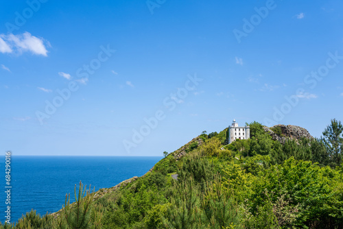 Monte Ulia Mount with the Faro de La Plata lighthouse under a clear blue sky and the Cantabrian Sea in background Pasaia  Gipuzkoa  Basque country  Spain