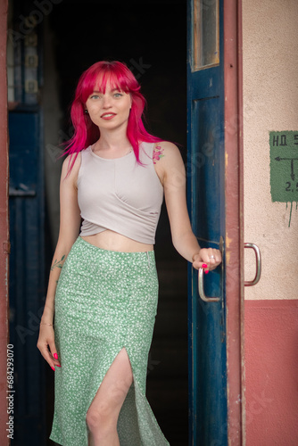 Portrait of a young beautiful girl with red hair in an urban environment.