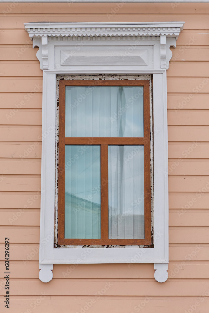 Typical timber window with carved architraves facade of 19th century residential building, Russia
