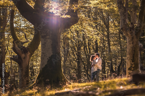 Lovers kissing standing in the middle of a forest