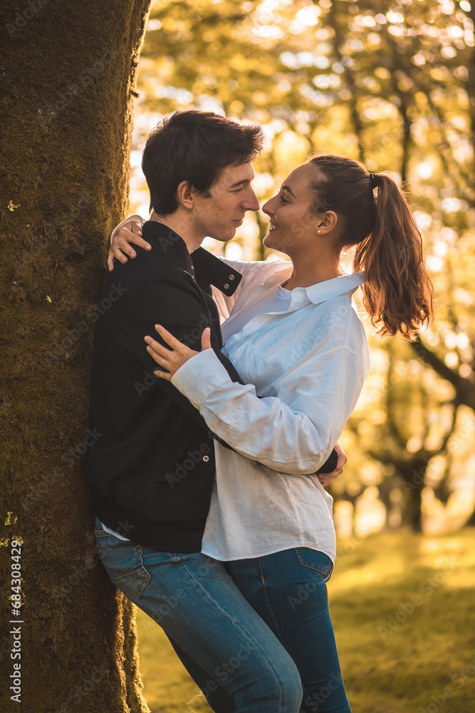 Romantic scene of couple about to kiss on a tree Romantic scene of couple about to kiss on a tree