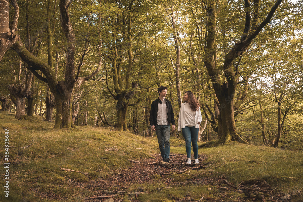 Fototapeta premium Lovers holding hands and walking in the forest
