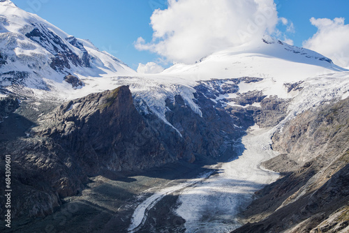 snow covered mountains with a glacier, blue sky and white clouds