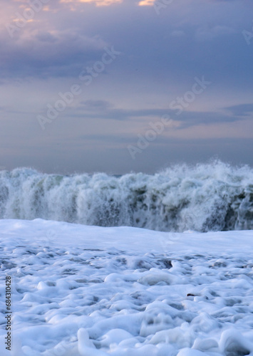 Sea waves and seas foam in the sunset