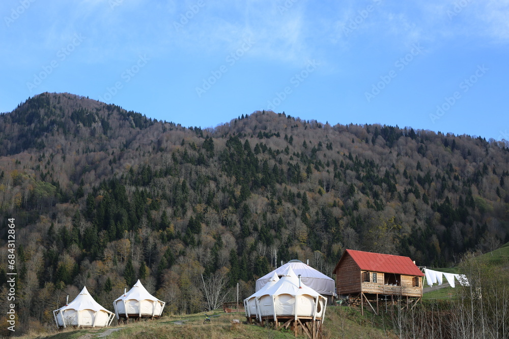 View of glamping tent on the nature in the beautiful countryside in the mountains in summer. White tent glamping camp. Luxury campsite.
View of glamping tent on the nature in the beautiful countryside in the mountains in summer. White tent glamping camp. Luxury campsite.